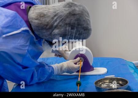 Outil jetable de sertissage de valvule cardiaque. Dans la salle d'opération, le médecin prépare la valve cardiaque pour la transplantation au patient porteur d'une valve cardiaque Banque D'Images