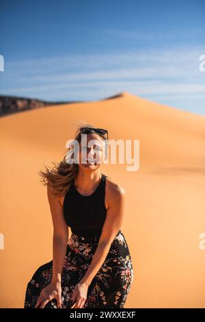 Femme marchant sur une dune de sable dans le désert à Coral Pink Sand Dunes State Park, Utah Banque D'Images