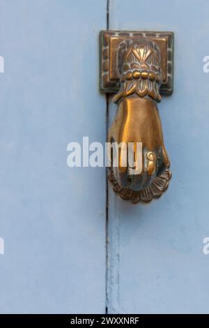 Main comme frappeur de porte sur une porte d'entrée bleue, Ile de Brehat, Bretagne, France Banque D'Images