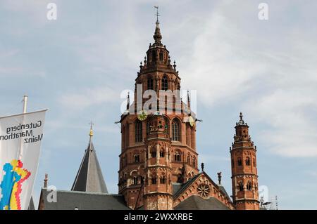 La haute cathédrale Saint-Martin à Mayence, tour d'église gothique avec un drapeau agitant devant un ciel nuageux, Mayence, Rhénanie-Palatinat, Allemagne Banque D'Images