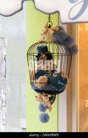 Ours en peluche dans une cage devant une boutique de souvenirs, Burano, Vénétie, Italie Banque D'Images