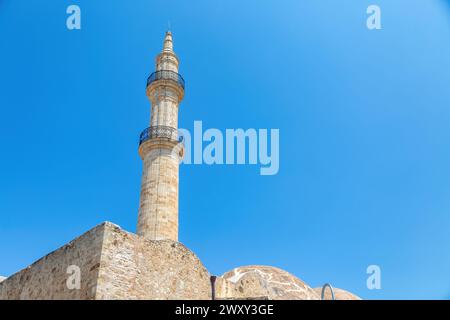 Mosquée Neratze Tour emblématique Minaret à Réthymnon ville, île de Crète, Grèce. Sous vue, partie supérieure du monument islamique sur fond de ciel bleu. Banque D'Images