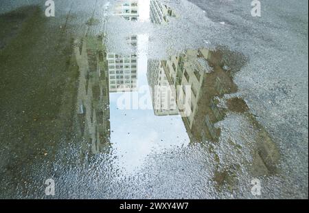 Hauts bâtiments se reflétant sur la flaque après la pluie Banque D'Images