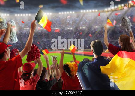 Fan de football belge au stade. Les supporters belges regardent le football en plein air. Les fans de l'équipe qui applaudissent célèbrent la victoire. Allez aux Red Devils ! Banque D'Images