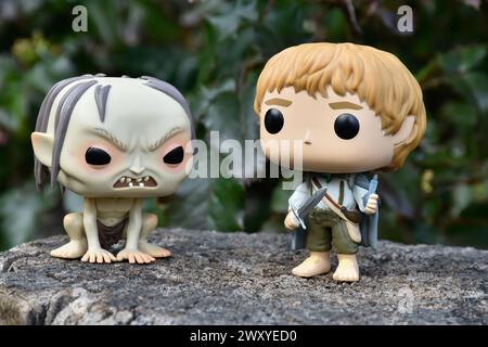 Funko Pop figurines d'action de Gollum et hobbit Sam du film fantastique le Seigneur des anneaux. Forêt sombre, souche d'arbre, feuilles vertes. Banque D'Images