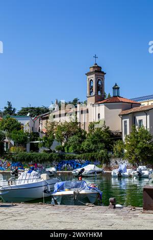 Vue sur l'église italienne et le canal avec des bateaux. Banque D'Images