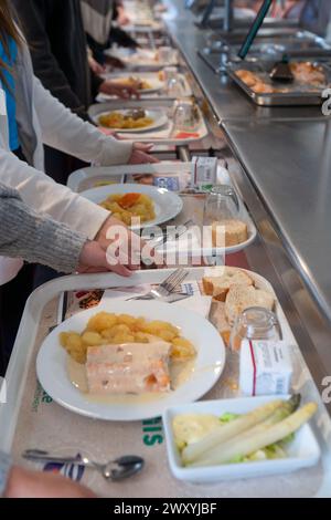 Déjeuner à la cantine du collège de la Voulte (sud-est de la France) : des élèves portant des plateaux avec repas Banque D'Images