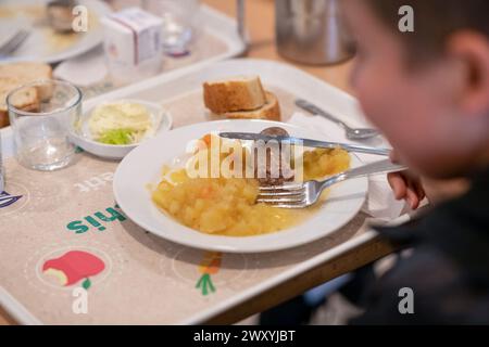 Déjeuner à la cantine du collège « collège de la Voulte » (sud-est de la France) : étudiant portant un plateau avec repas Banque D'Images