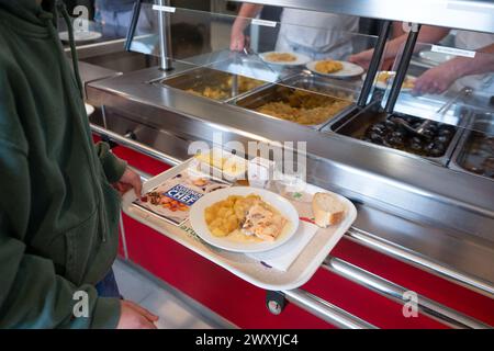 Déjeuner à la cantine du collège « collège de la Voulte » (sud-est de la France) : étudiant portant un plateau avec repas Banque D'Images