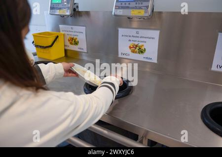 Déjeuner à la cantine du collège de la Voulte (sud-est de la France) : une étudiante trie les déchets après le déjeuner, vidant son pl Banque D'Images