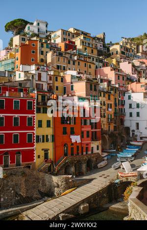 Une vue vibrante de maisons multicolores empilées le long de la falaise d'un charmant village côtier, avec des bateaux amarrés le long du rivage Banque D'Images