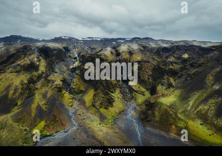 Une prise de vue aérienne époustouflante capture le paysage spectaculaire des hautes terres islandaises, avec des cascades en cascade et un terrain couvert de mousse sous un Banque D'Images