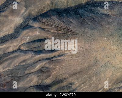 Plan aérien capturant les textures et les motifs complexes du paysage volcanique de Fuerteventura, idéal pour les aventures de surf. Banque D'Images