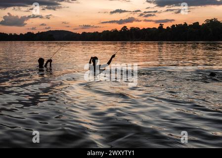 Papaitchon, rivière Maroni (ou Marowijne), Guyane française : les enfants s'amusent, jouent et pêchent au coucher du soleil Banque D'Images