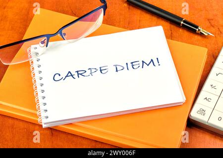 La phrase latine Carpe Diem, une citation de Horace, signifie saisir l'instant. Vivez dans le présent écrit sur un cahier blanc propre Banque D'Images