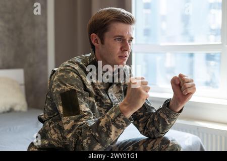 Jeune homme caucasien portant l'uniforme de l'armée de camouflage en colère et furieux Banque D'Images