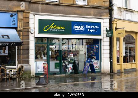 Une boutique combinée Johnsons Specialist Cleaning et Max Spielmann photo Expert sur Market place, Cirencester. Concept : shopping dans la rue Banque D'Images