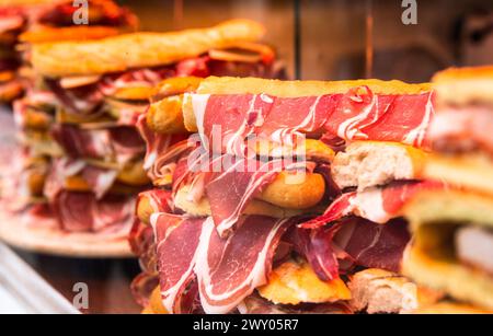 Délicieux jambon suspendu à des sandwichs dans une vitrine de magasin Banque D'Images