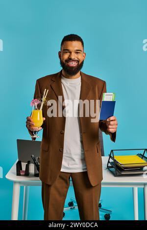 Un homme sophistiqué dans un costume pointu tenant une boisson dans une main et un livre dans l'autre, exsudant l'élégance et la culture. Banque D'Images