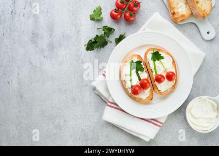 Toast drôle en forme de sandwich aux cerises mûres avec fromage à la crème, pain, tomate cerise, oignon et persil. Idée d'art alimentaire pour la nourriture des enfants. Pause créative Banque D'Images