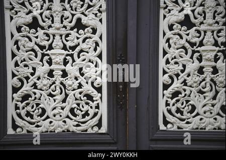 Grilles anciennes en fonte à travail ouvert sur une porte d'entrée en bois vintage à Obernai, Alsace France. Banque D'Images