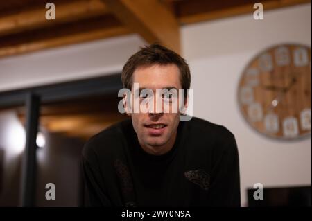 Portrait d'un jeune homme qui regarde la caméra, a un visage fou ou effrayé. Il a des pupilles très dilatées. Il est dans un appartement rustique et chaleureux Banque D'Images