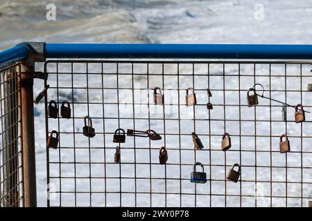 cadenas sur des clôtures de fil de fer à des balustrades près de la mer à seaford symbolisant l'amour des gens les uns envers les autres et jetant la clé pour garder l'amour verrouillé Banque D'Images