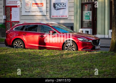 OSTRAVA, RÉPUBLIQUE TCHÈQUE - 4 MARS 2024 : Mazda 6 Wagon break voiture de couleur rouge au coucher du soleil Banque D'Images