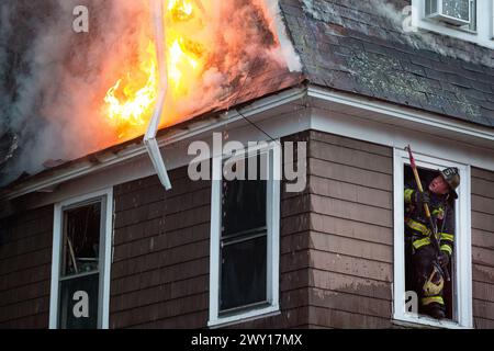 Les pompiers travaillent pour éteindre un incendie de plusieurs maisons d'alarme à Worcester, Massachusetts, États-Unis. Banque D'Images