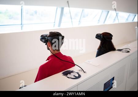 Visiteurs essayant des lunettes de réalité virtuelle au Mobility City Technology Museum du pont de Zaha Hadid (Pavillon du pont), Saragosse, Espagne Banque D'Images