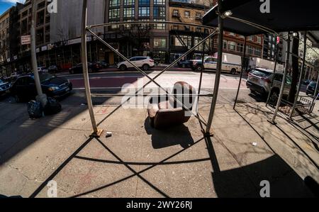 Un fauteuil jeté sous un échafaudage du quartier de Chelsea à New York le dimanche 31 mars 2024. (© Richard B. Levine) Banque D'Images