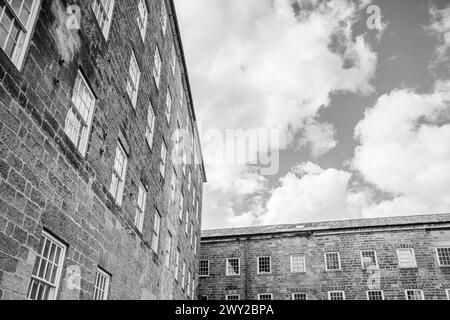 Une image en noir et blanc de deux bâtiments qui composent le moulin de Cromford vu près de Matlock dans le Derbyshire en mars 2024. Banque D'Images