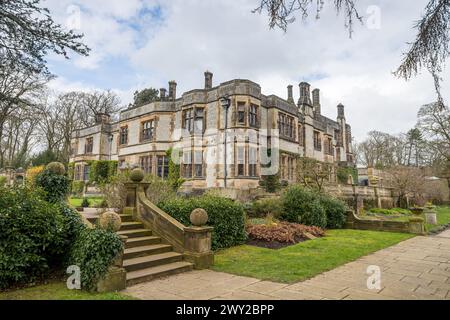 Une image HDR de Thornbridge Hall encadrée par des arbres dans son jardin formel photographié près de Bakewell dans le Derbyshire en mars 2024. Banque D'Images