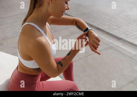 Gros plan d'une femme regardant smartwatch et comptant les calories brûlées. Concept de vie saine Banque D'Images