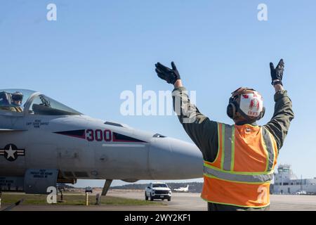 Le Cpl Brandon Buck, spécialiste du carburant en vrac affecté au quartier général et à l'escadron du quartier général de la Marine corps Air Station Cherry point, signale au pilote d'un F/A-18E Super Hornet, affecté au Strike Fighter Squadron 31 de la Naval Air Force Atlantic, sur la ligne de vol à MCAS Cherry point, Caroline du Nord, 21 mars 2024. MCAS Cherry point Station Fuels est responsable de la réception, de l'essai, de l'entreposage et de la distribution de divers produits pétroliers à l'appui des opérations terrestres et aériennes sur l'installation. (Photo du corps des Marines des États-Unis par le caporal Lauralle Gavilanes) Banque D'Images