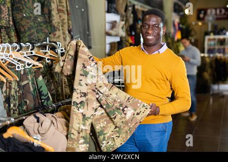 Homme choisissant des vêtements de camouflage Banque D'Images