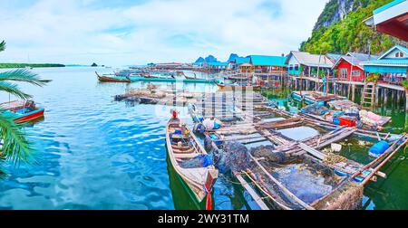 Panorama avec fermes piscicoles et vieux bateaux de pêche sur la rive du village flottant de Ko Panyi avec des maisons sur pilotis, Phang Nga Bay, Thaïlande Banque D'Images