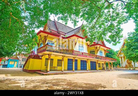 La cour verdoyante du temple de la grotte de Wat Suwan Kuha avec de grands arbres étendus et des bâtiments monastiques, Phang Nga, Thaïlande Banque D'Images