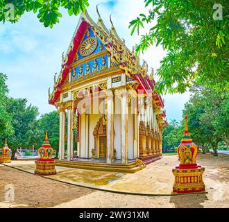 L'époustouflant Ubosot du temple Wat Suwan Kuha avec des décors sculptés et sculptés, toit multi-fatigué et bargeboards en bois doré avec des serpents Naga, Phan Banque D'Images