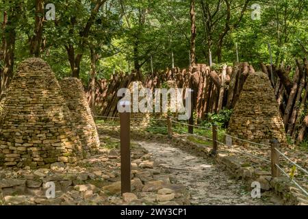 Sentier de randonnée entre deux rangées de cairns (piles de pierres) sous les arbres d'ombre dans le parc forestier en Corée du Sud Banque D'Images