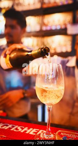 25 mars 2023, Pune, Maharashtra, Inde. Barman versant un vin blanc dans un verre Banque D'Images