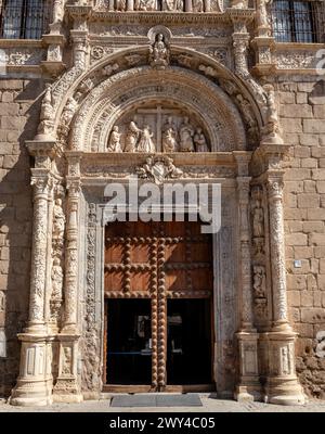 Le devant d'un bâtiment avec une grande arche et une croix dessus. L'arche est décorée de statues de personnes Banque D'Images