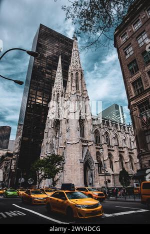 Taxis jaunes et verts passant par obtention Cathédrale Patrick sur la Cinquième Avenue - Manhattan, New York Banque D'Images