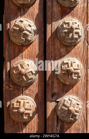 Une porte en bois avec un certain nombre de boutons décoratifs dessus. Scène est une de charme rustique et de simplicité. Est la porte d'entrée o une église à Tolède Banque D'Images