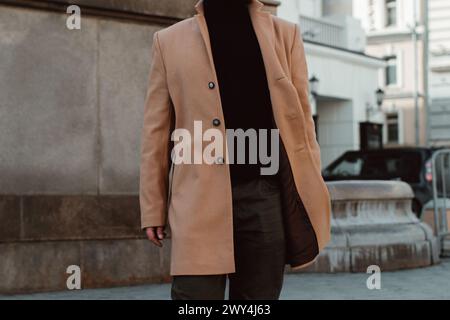 Détails du manteau pour homme brun beige, pantalon et col roulé noir. Vêtements d'extérieur de rue classiques Banque D'Images