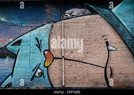 Lutsk, Ukraine - mars 2024 : une murale graffiti vive et audacieuse orne un mur de briques, mettant en valeur le Street art et la créativité urbaine avec un design abstrait, Banque D'Images