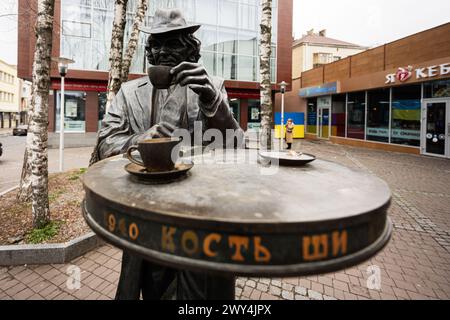 Lutsk, Ukraine - mars 2024 : Monument de Kostya Shishko à Lutsk, Ukraine. Statue de bronze avec l'homme dans le chapeau boire du café à la ville. Banque D'Images