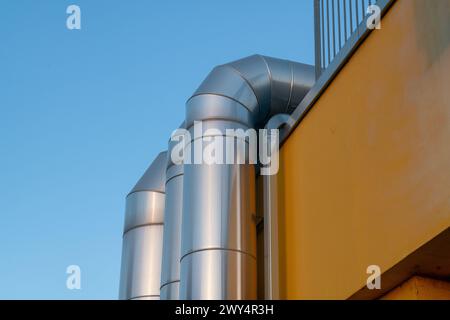 tuyaux du système de ventilation dans le bâtiment, détail détaillé avec des éléments qui reflètent la lumière chaude du soleil d'été. système de climatisation et de ventilation Banque D'Images