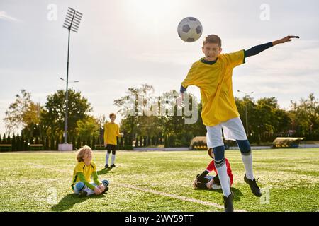 Un groupe de jeunes hommes jouant énergiquement au football sur un terrain vert, frappant le ballon, courant et acclamant avec passion et détermination. Banque D'Images