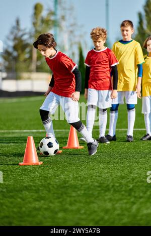 Un groupe de jeunes enfants jouant énergiquement à une partie de soccer, courant, donnant des coups de pied et riant sur un terrain herbeux. Certains gosses dribblent la balle, Banque D'Images